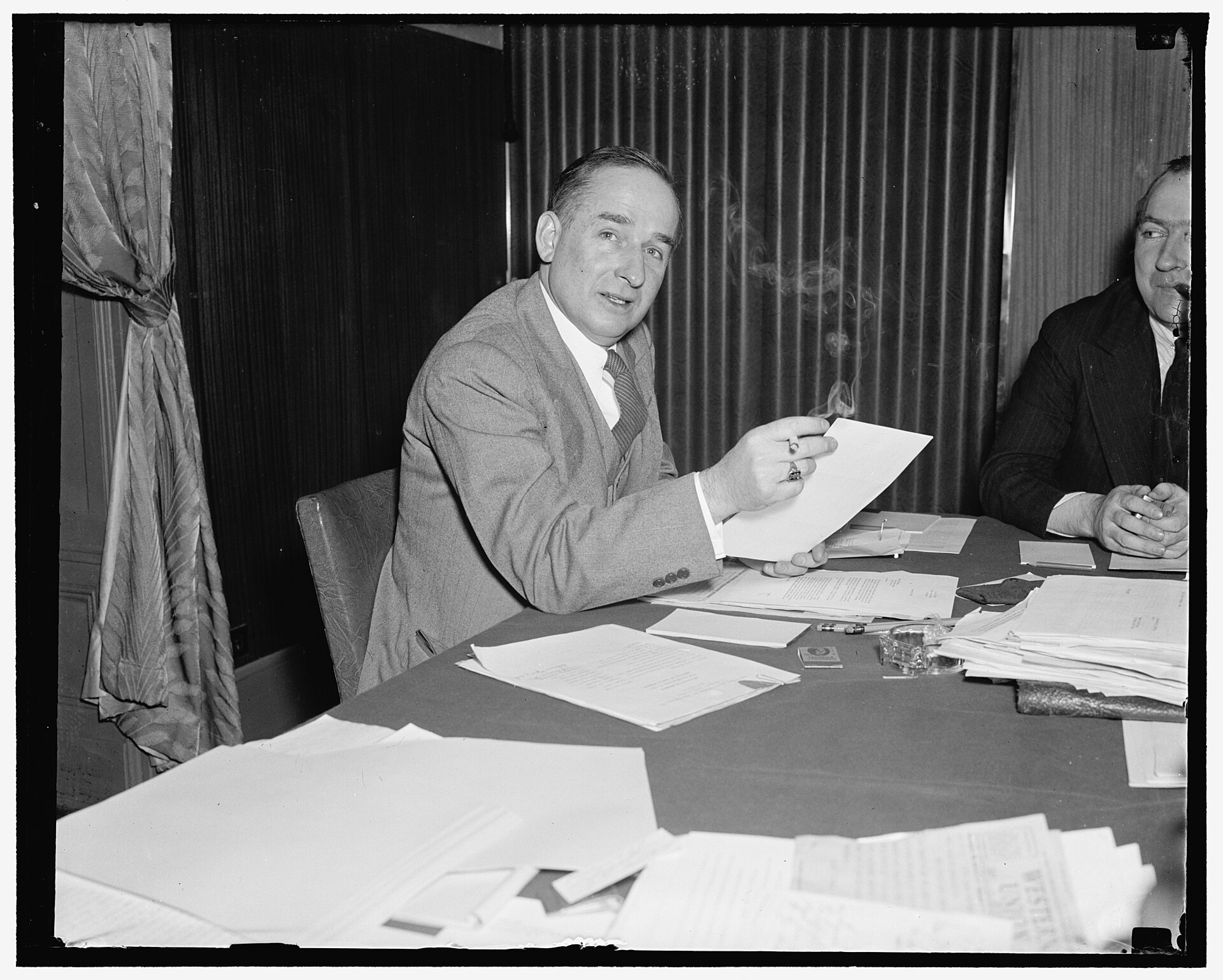 Two men review chart data and documents, illustrating how television adopted the radio countdown format.